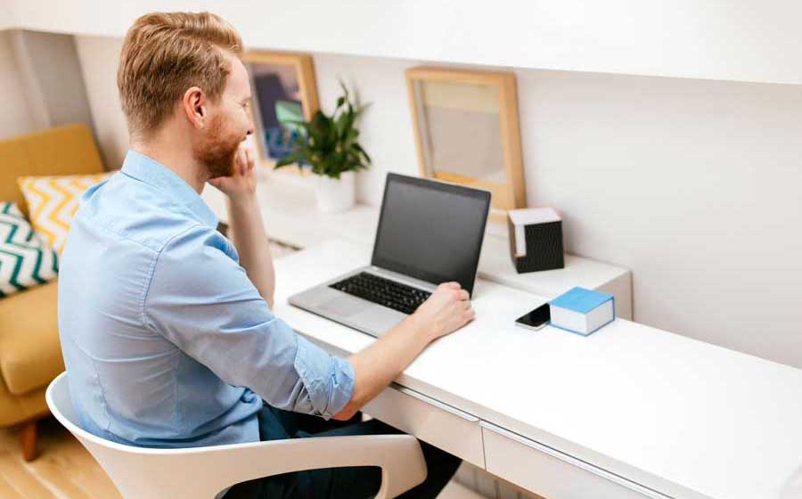 Ein kollege mit einem Laptop am Arbeitstisch
